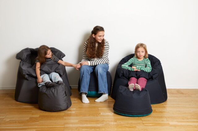 three young girls sitting on a Protac Sensit Jr chairs